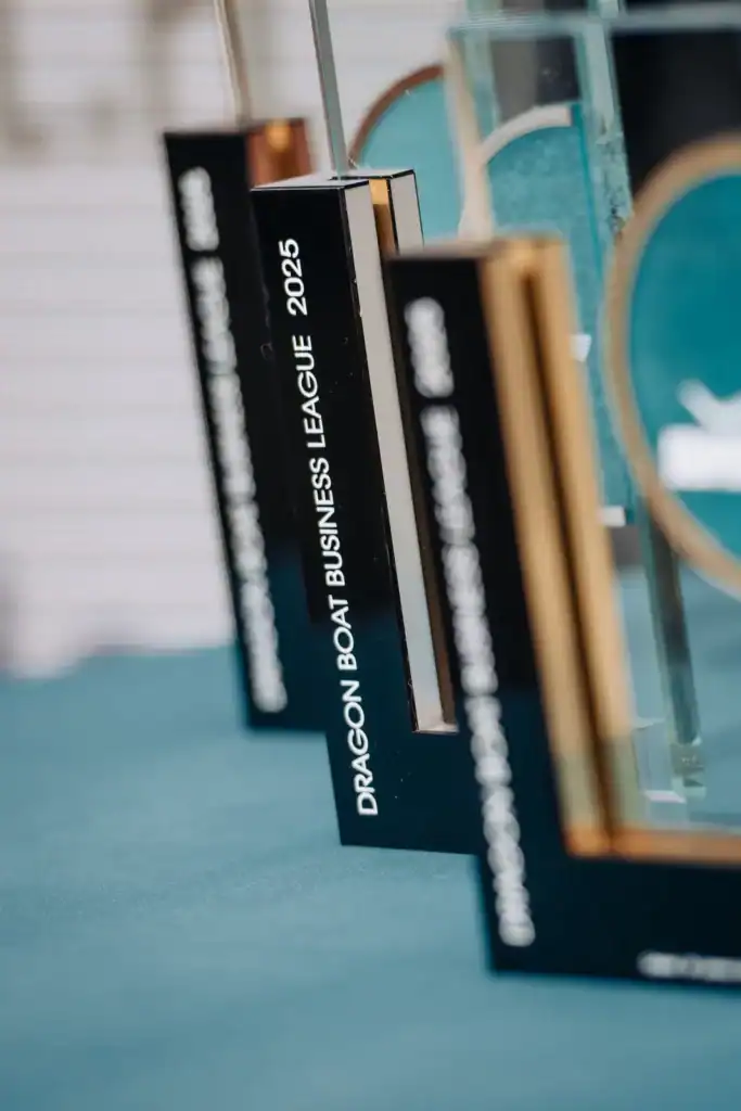 Trofea i puchary z logo Dragon Boat Business League 2025, symbolizujące rywalizację i sukces w branży.